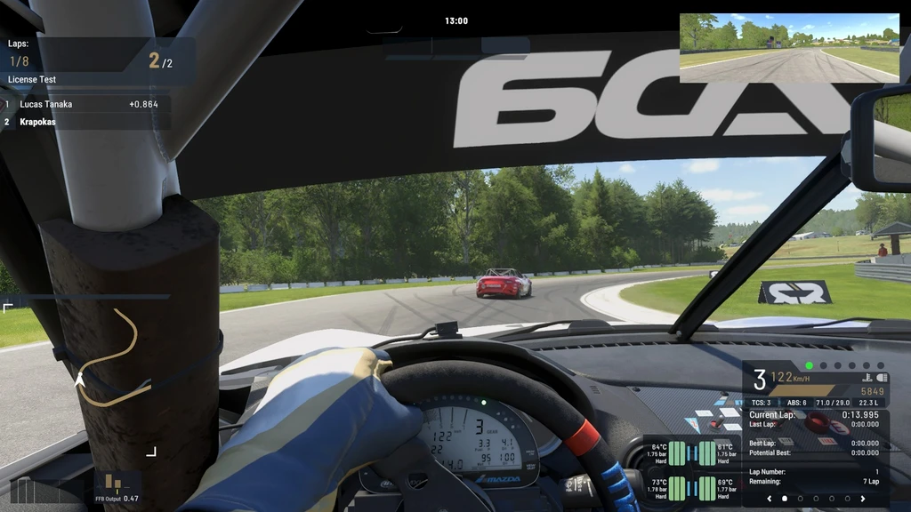 Förarvy inifrån en tävlingsbil i Project Motor Racing. En röd sportbil ligger framför i en kurva på en bana omgiven av grönska under ett licenstest.