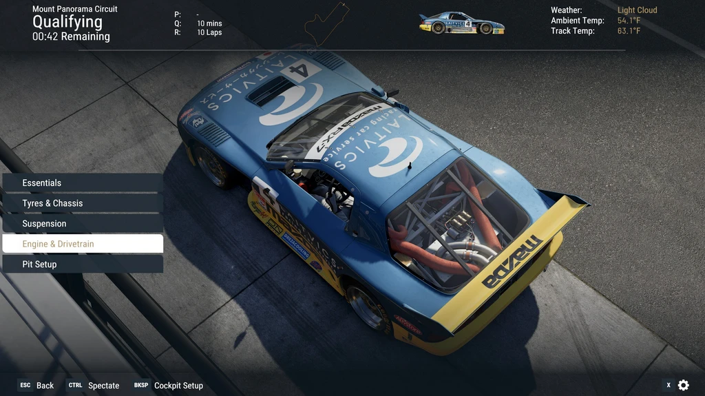 Project Motor Racing: blå och gul Mazda RX-7 med nummer 4 sedd uppifrån i depån på Mount Panorama Circuit, med inställningsmenyn öppen under kvalet.