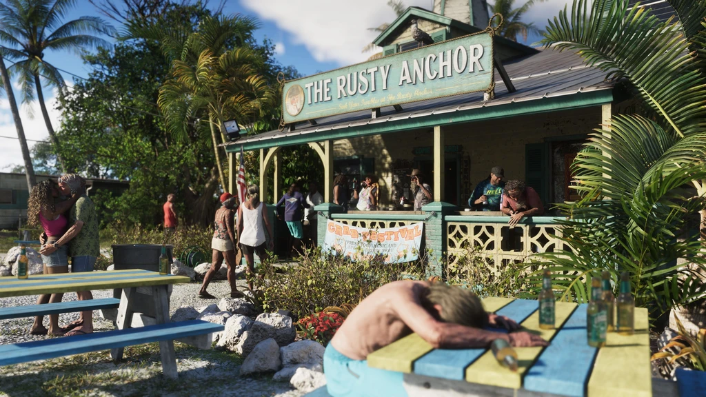 Solig strandbar med skylten The Rusty Anchor i GTA VI. Gäster står och sitter under verandan medan en man ligger framstupa över ett picknickbord med flaskor.
