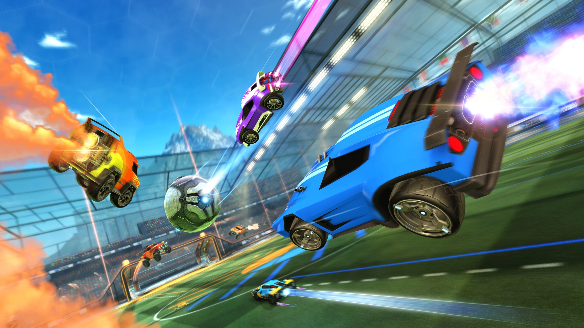 Rocket League: bilar med raketdrivning flyger genom luften över en gräsbana i en glasad arena och jagar en stor boll, med en blå bil i förgrunden.