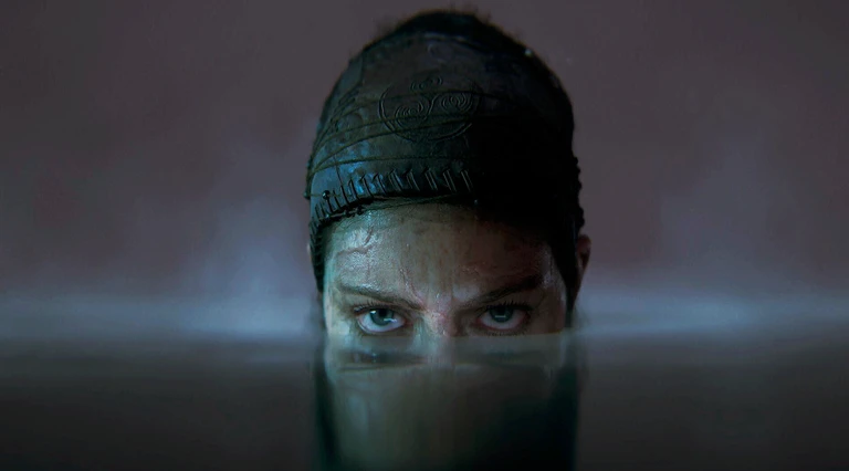 Senua i Senua's Saga: Hellblade II stirrar med blå ögon rakt fram med ansiktet halvt under vattenytan, med mörkt tygband runt huvudet.