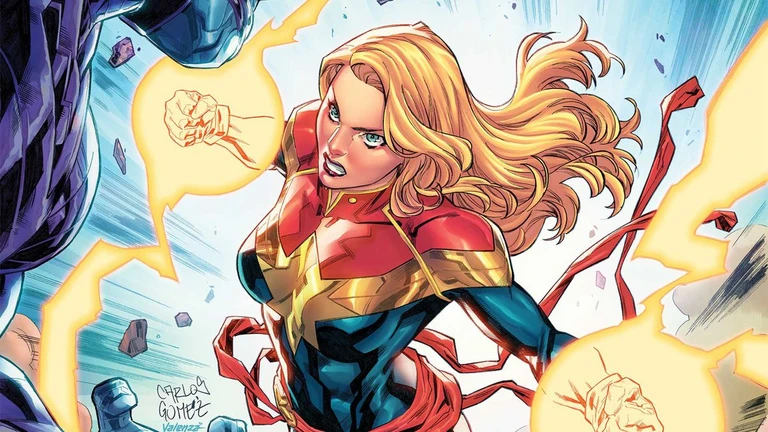 Captain Marvel i röd och blå dräkt med lång blond hög hårfläta flygande genom luften, med glödande energi runt knytnävarna medan hon slår mot en mörk motståndare.