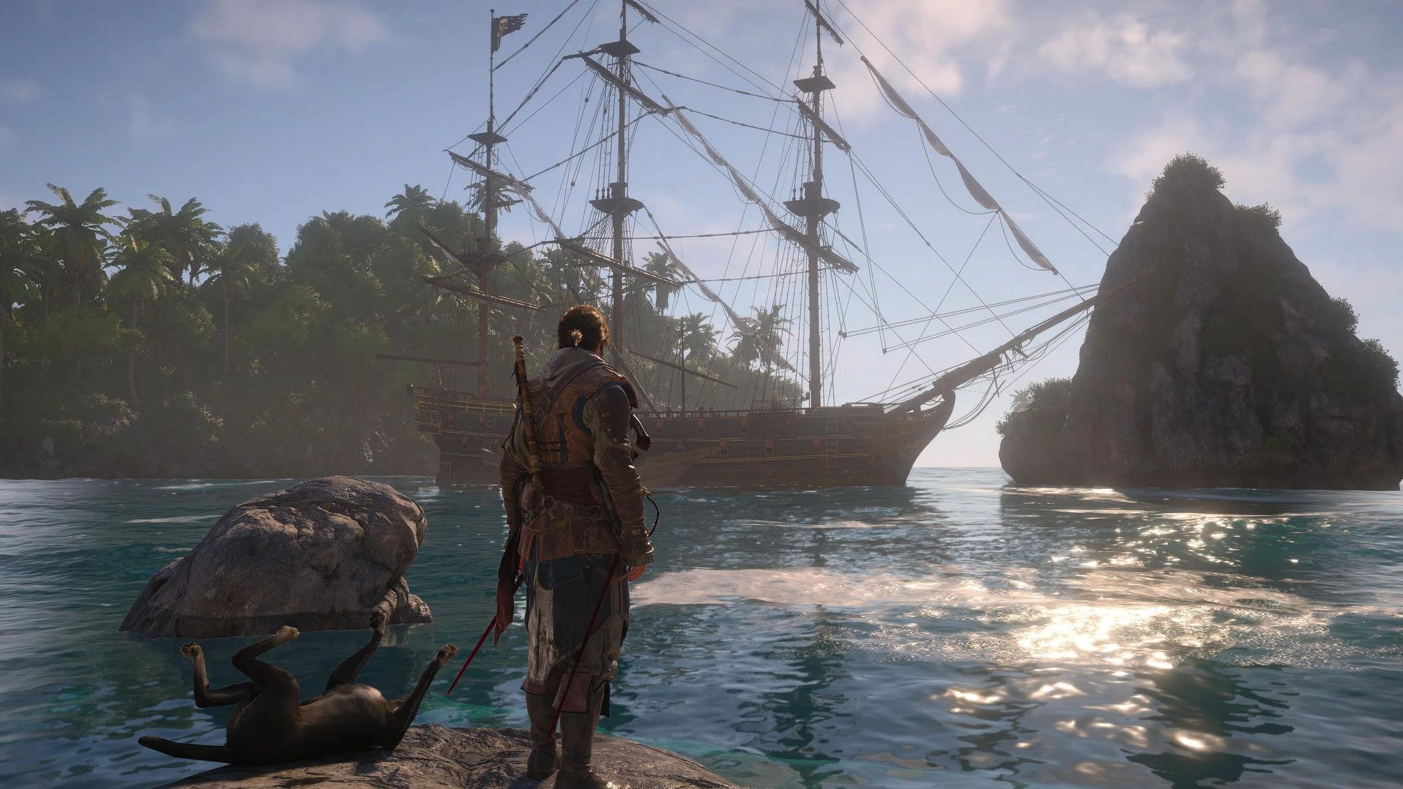 Edward Kenway står på en klippa vid havet i Assassin's Creed Black Flag Resynced och blickar mot ett stort segelfartyg vid en palmklädd ö, medan en död hjort ligger vid hans fötter.