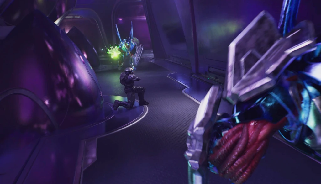 I Halo: Campaign Evolved knäböjer en pansarklädd soldat i en lila upplyst korridor och skjuter mot en blåaktig utomjording, medan en annan utomjordings beväpnade arm skymmer bildens förgrund.