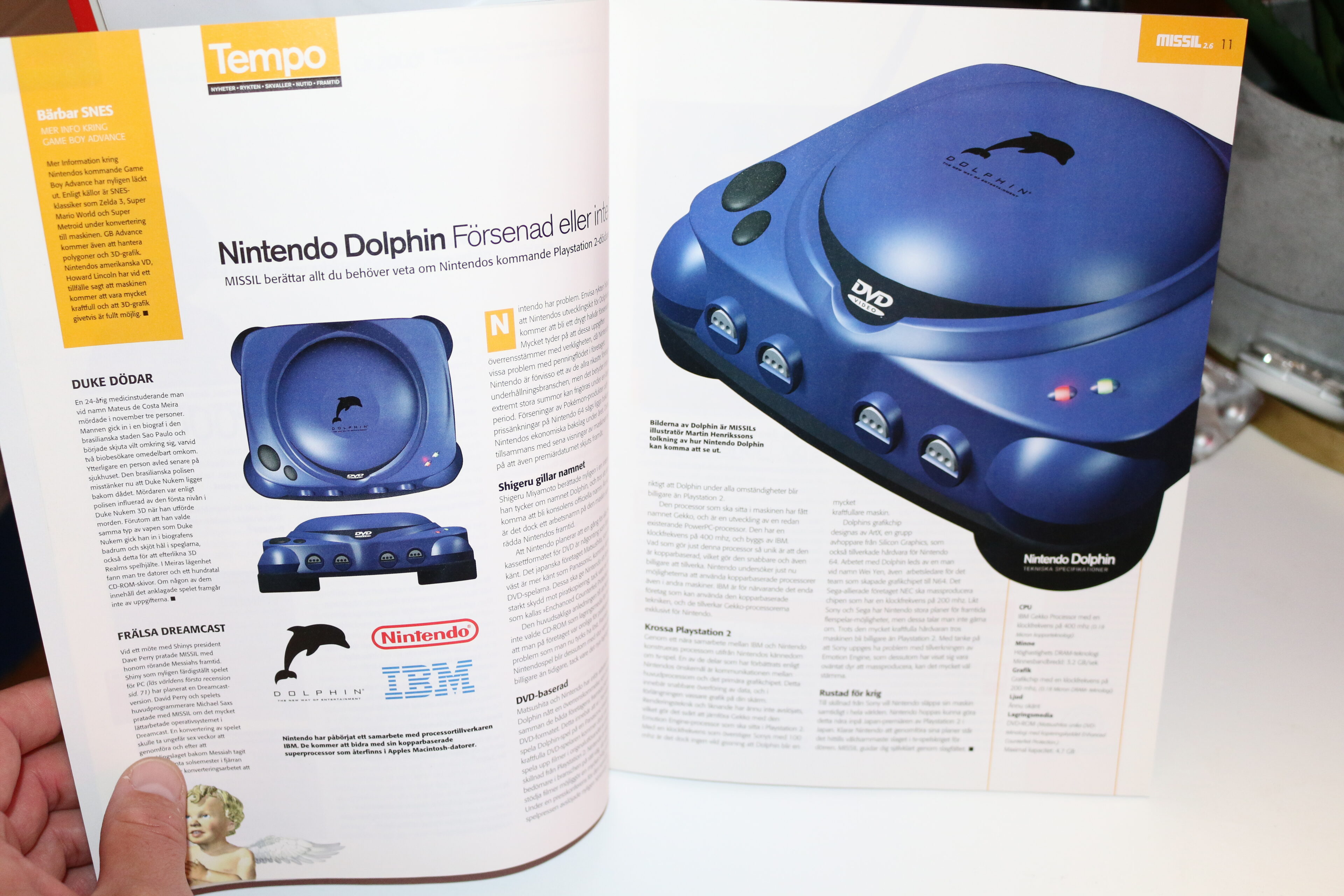 Uppslag i tidningen MISSIL med artikel om Nintendo Dolphin, en blå spelkonsol med delfinlogotyp och dvd-läsare, bredvid logotyper för Nintendo och IBM.