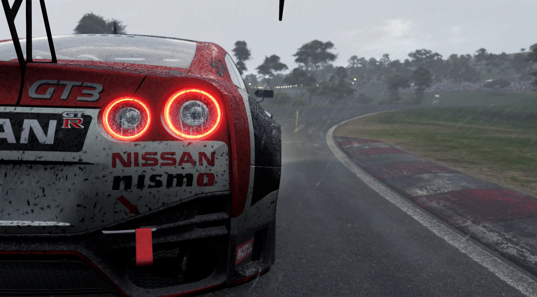 Baksidan av en röd och vit Nissan GT-R GT3 med lysande bakljus på en blöt racerbana i regn, med skog längs kurvan i Automobilista 2.