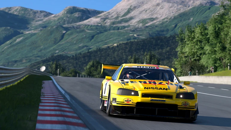 Gul Nissan Skyline GT-R i Pennzoil-färger kör på en bergsbana med kantstenar och gröna sluttningar i Gran Turismo 7.