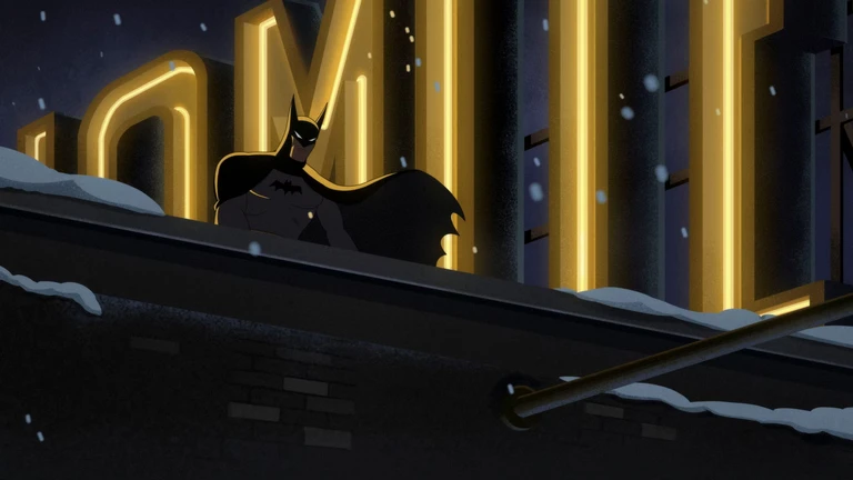 Batman står på ett snötäckt tak nattetid framför stora gulgnistrande neonbokstäver, med manteln svepande bakom sig medan snön faller.