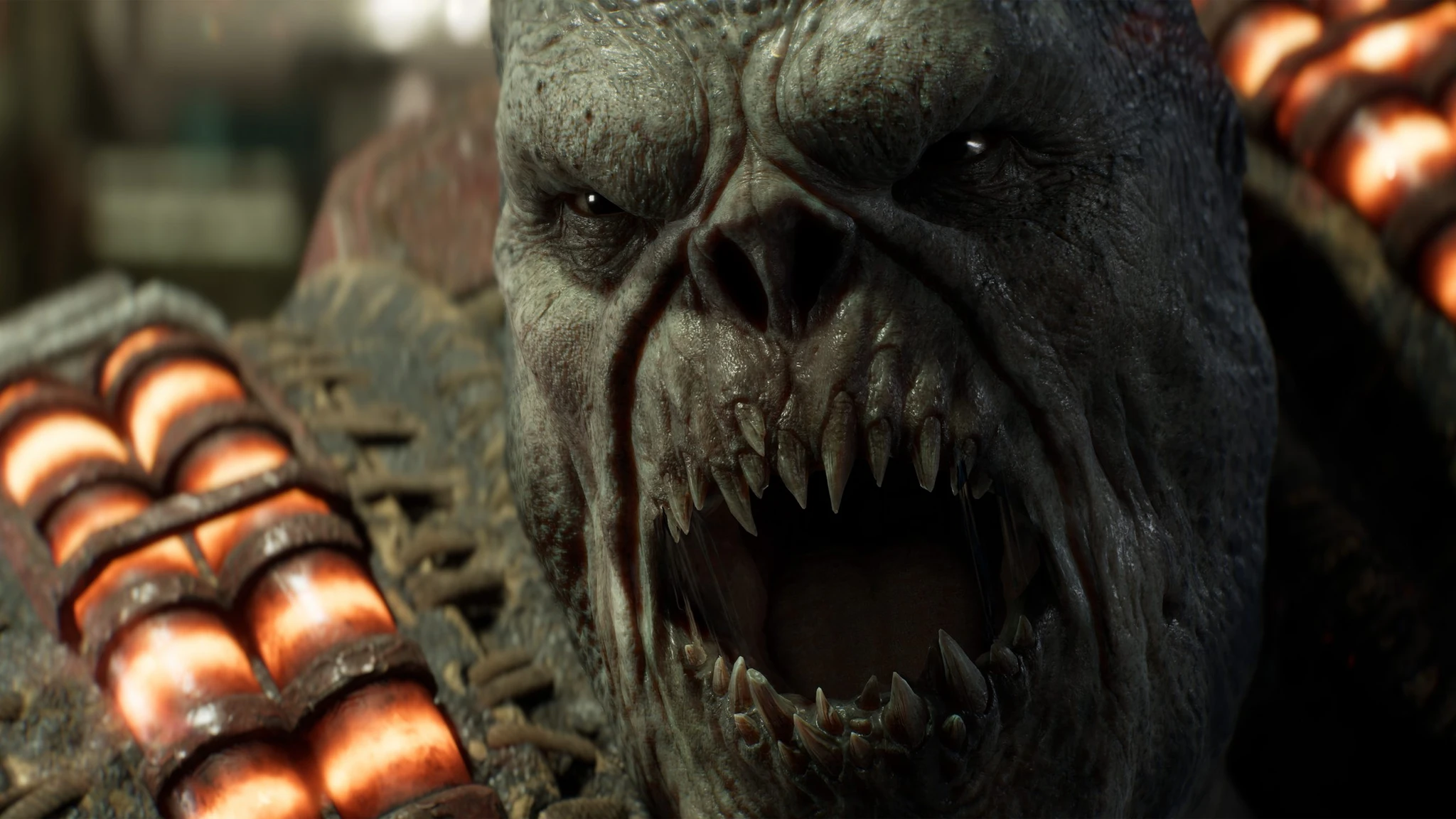Närbild på en gråhudad Locust-drönare med vidöppen mun full av vassa tänder, omgiven av glödande ammunitionsbälten, i Gears of War: E-Day.