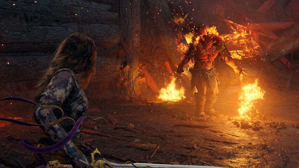 Från God of War Laufey: en kvinnlig karaktär med långt hår och lila band om armarna ser mot en brinnande, eldomsluten best i en förstörd träbyggnad.