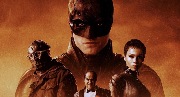 Batman i mask och cape tornar upp sig i regnet över fyra andra gestalter: en man med skyddsglasögon och mask, en man i smoking och en kortklippt kvinna i svart dräkt, allt i orange ton.