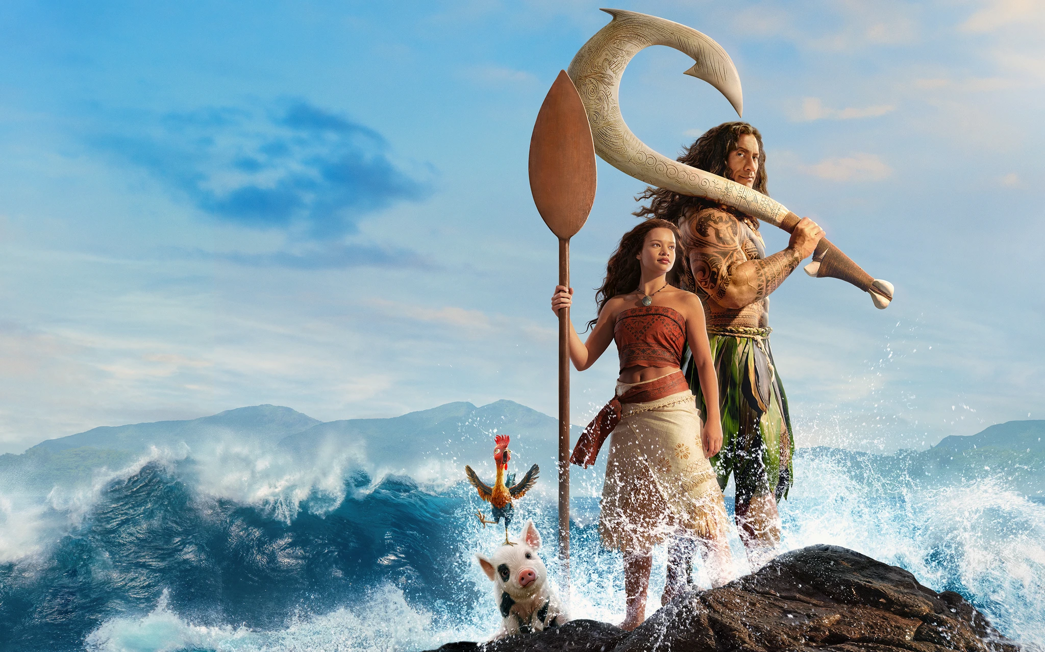 En ung kvinna med en åra och en lång man med en stor krokformad fiskekrok står på en klippa vid vågor, med en gris och en tupp framför dem. Moana i live action.
