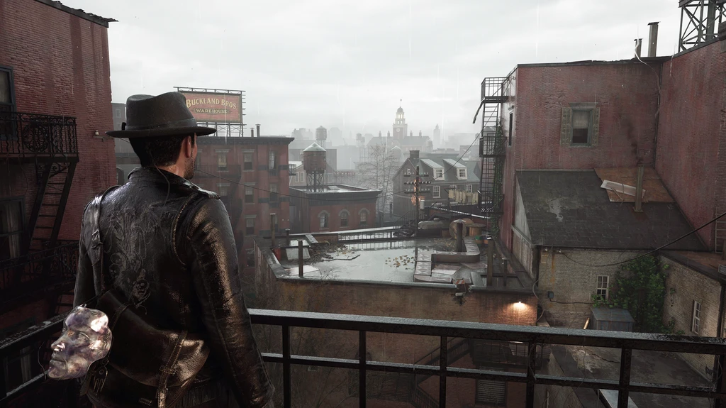 Privatdetektiven i hatt och skinnjacka står på en balkong och blickar ut över regntunga hustak och en dimmig stad i The Sinking City 2.