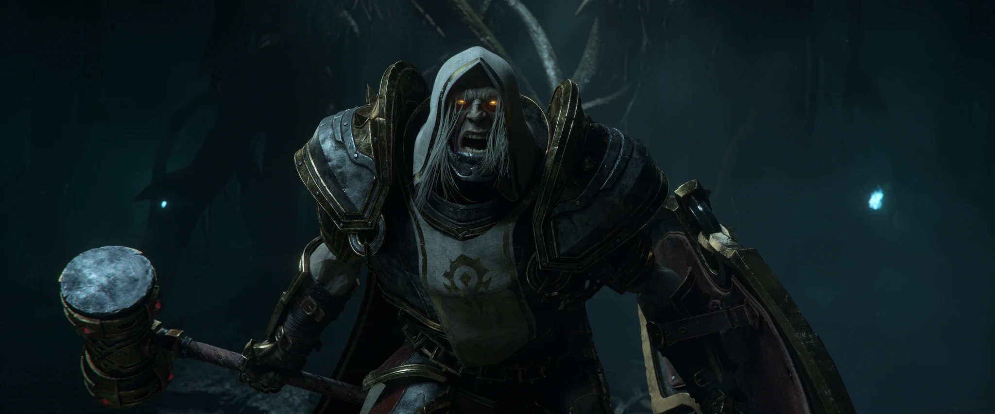 En skrikande, kapuschklädd krigare med glödande orangea ögon och tung rustning håller en stor stridshammare i ett mörkt, blåskimrande grottlandskap i World of Warcraft.