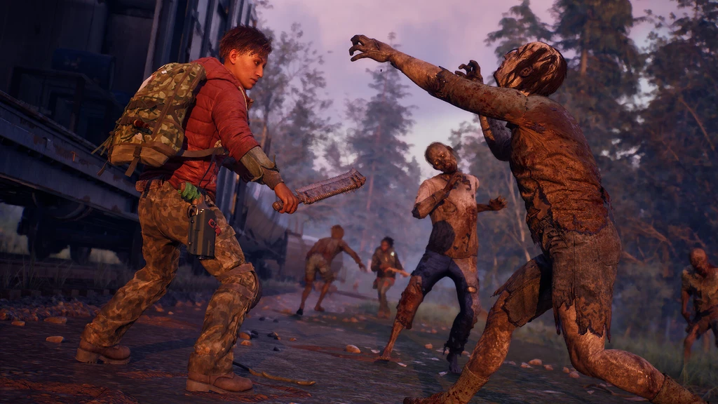 En överlevare i röd jacka och kamouflagebyxor med ryggsäck svingar ett vasst tillhygge mot en lerig zombie som sträcker sig fram, på en skogsväg i State of Decay 3.