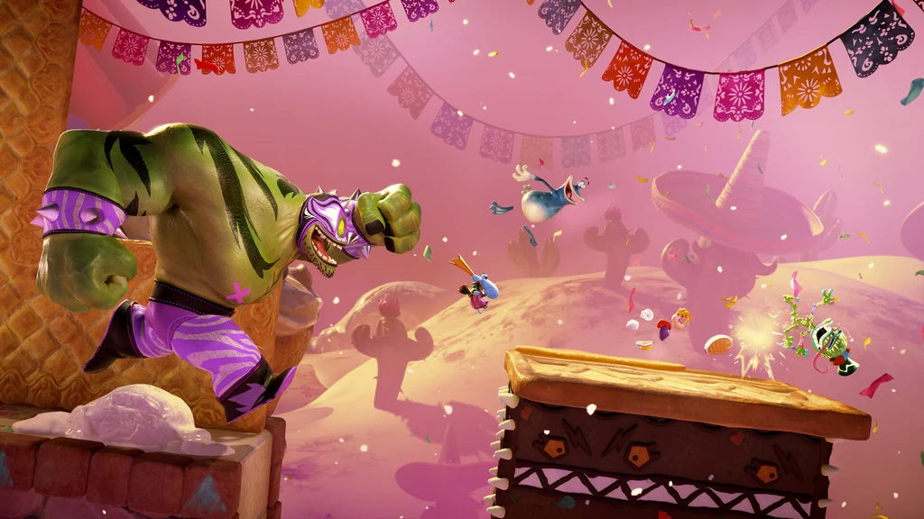 Rayman Legends: en stor grön luchadorfigur med lila mask slår mot hjältarna som hoppar över en kaka i en rosa, mexikansk fiestavärld med flaggspel och konfetti.