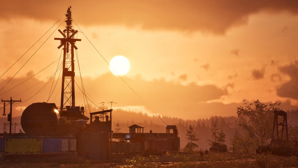 Solnedgång över en förfallen industriplats med en hög radiomast, en stor tank och containrar, omgiven av skog under orangefärgade moln i State of Decay 3.