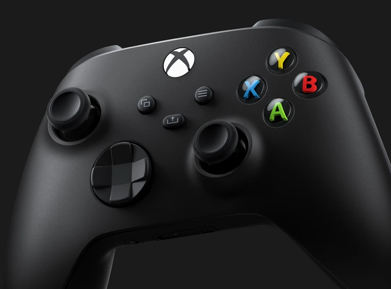 Svart Xbox-handkontroll i närbild med färgade knappar X, Y, B och A, två spakar och ett riktningskors mot mörk bakgrund.