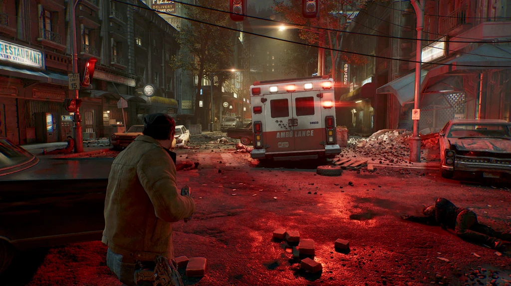 Gears of War: E-Day. En man i jacka kryper ihop bakom en bil på en förstörd, rödbelyst stadsgata med en ambulans, spillror och en livlös kropp på asfalten.