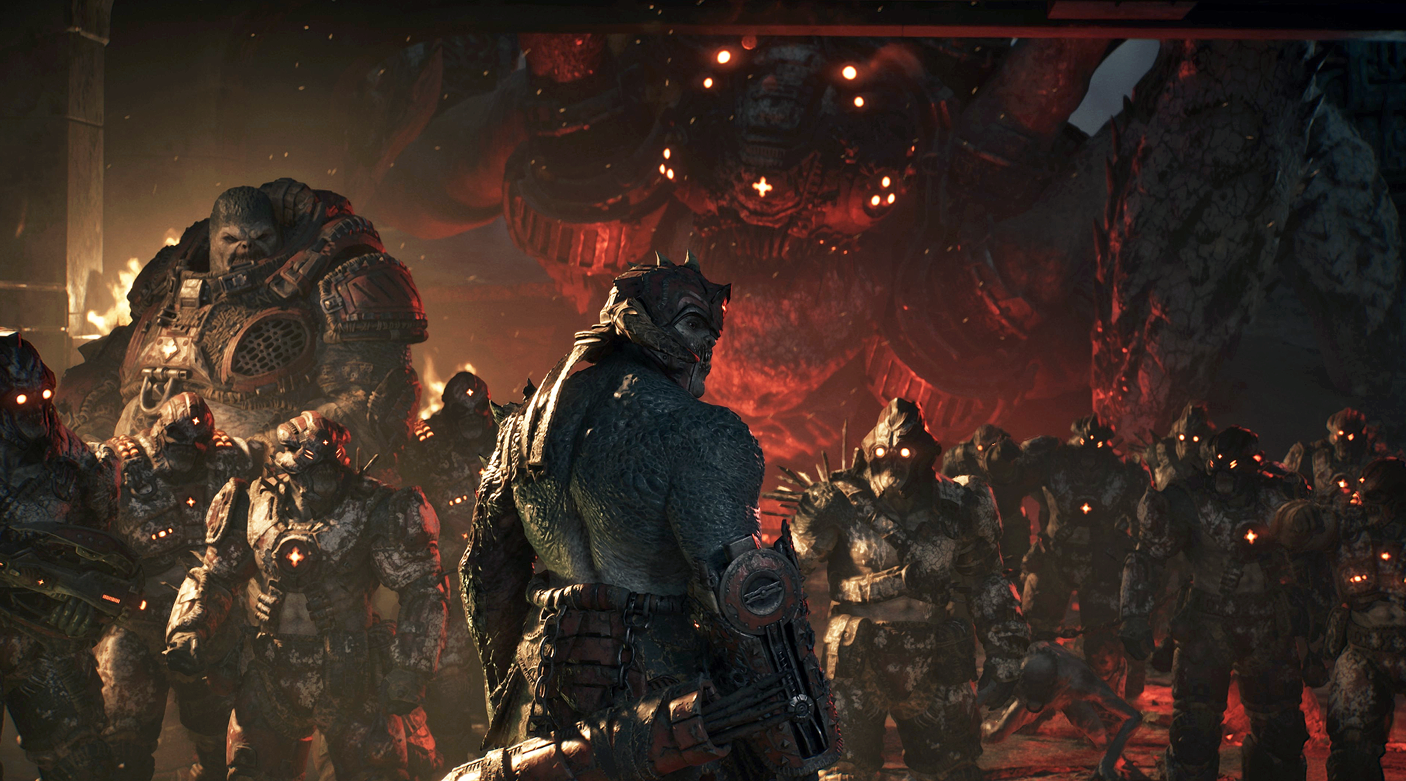 Gears of War: E-Day: en pansarklädd Locust-krigare sedd bakifrån står framför en skara glödande rödögda soldater och en gigantisk eldbelyst varelse i bakgrunden.
