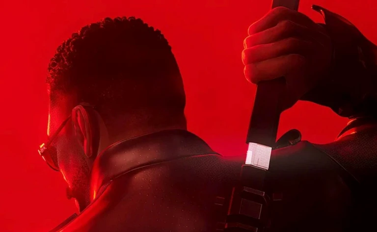 Man med solglasögon sedd bakifrån mot röd bakgrund, i läderjacka med en svärdshandtag som sticker upp över axeln. Bild som hör till Marvel's Blade.