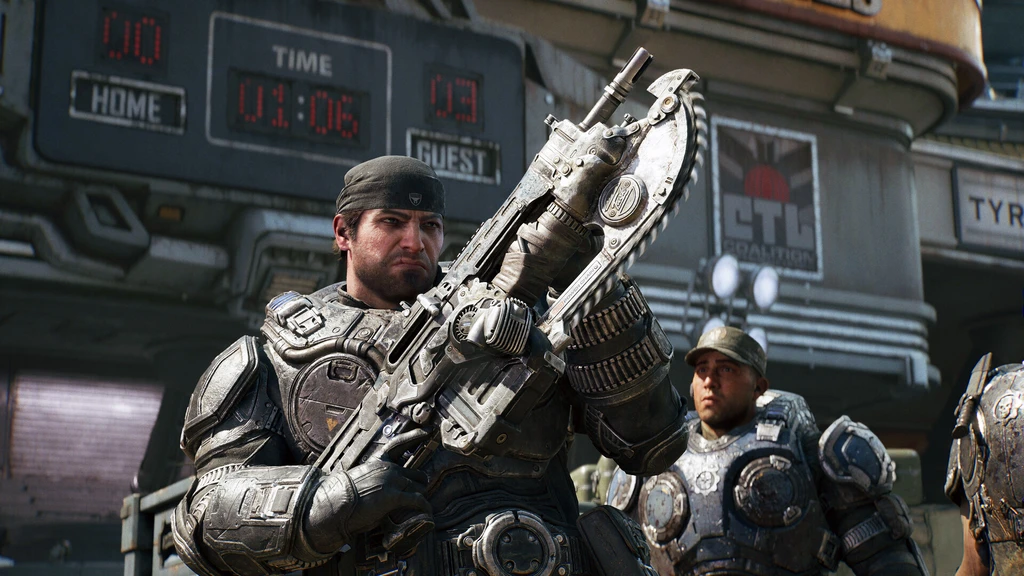 Soldat i tung rustning håller upp ett Lancer-gevär med motorsågsbajonett framför en stor resultattavla, med en kamrat i bakgrunden, i Gears of War: E-Day.