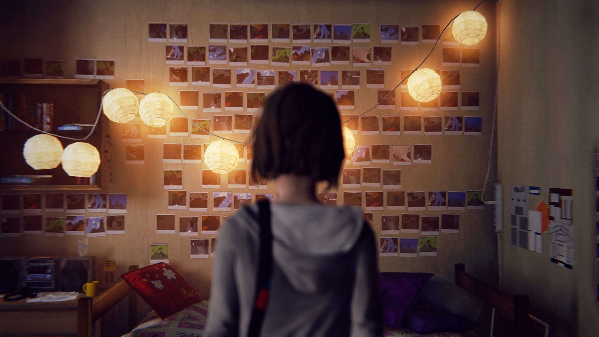 Max står med ryggen mot kameran i sitt sovrum i Life Is Strange och tittar på en vägg full av polaroidfoton, upplyst av små lysande lyktor.