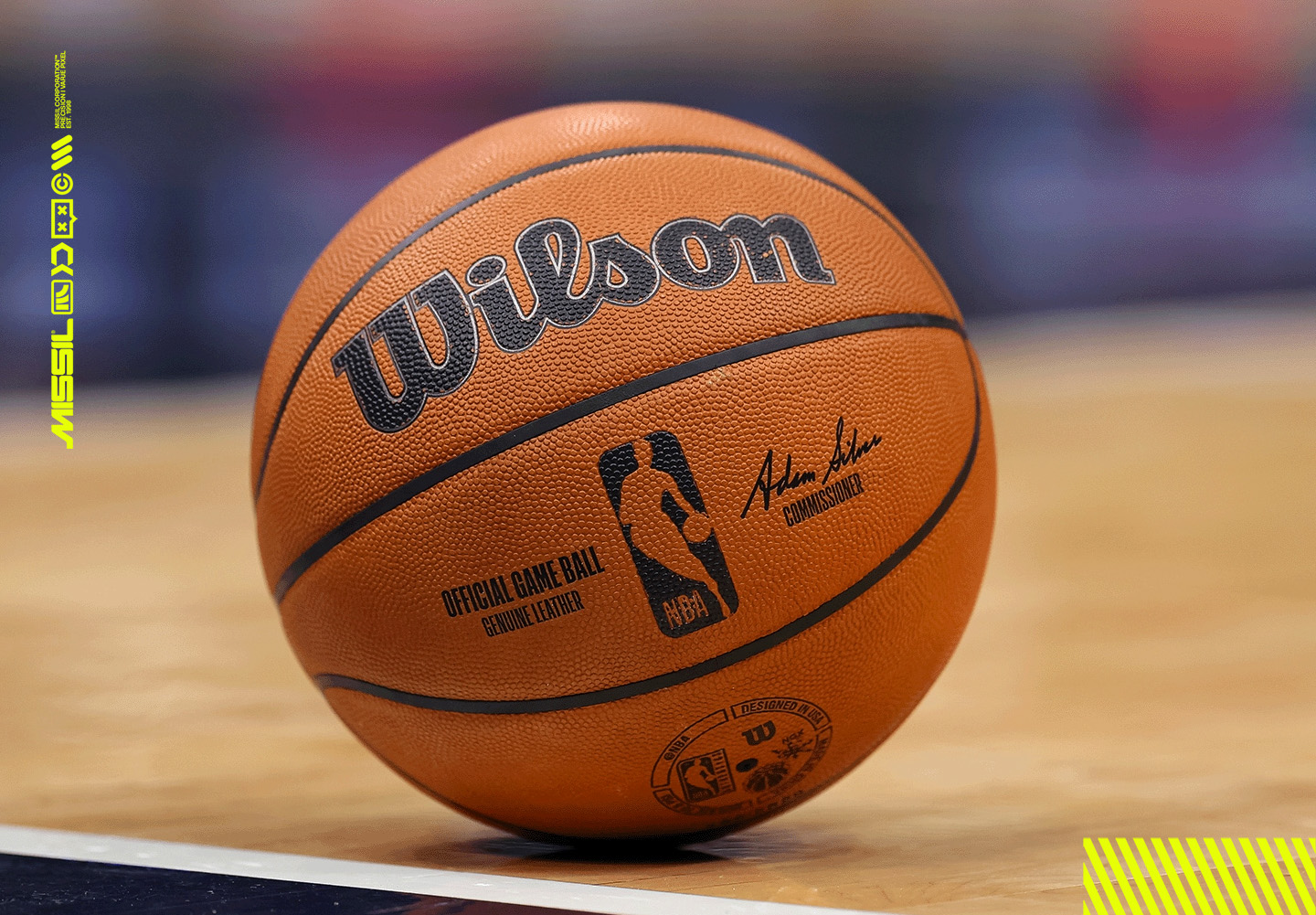 Närbild på en orange Wilson-basketboll med NBA-logotyp som ligger på ett parkettgolv bredvid en sidlinje i en hall.
