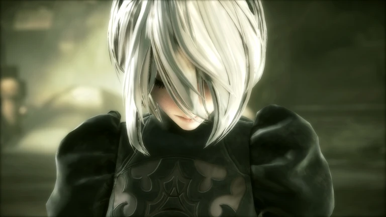 Närbild på en karaktär med kort vitt hår som hänger ner över ansiktet och sänkt blick, klädd i svart klänning med puffärmar, i en dunkel miljö från Nier: Automata.
