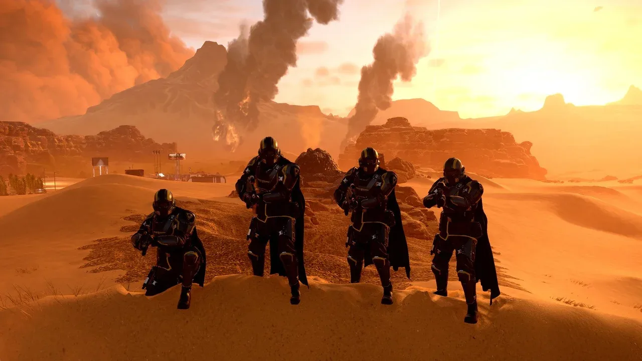Fyra pansarklädda soldater med mörka kappor står på en sanddyn i en orange öken i Helldivers 2, med rökpelare från brinnande platser bakom sig.