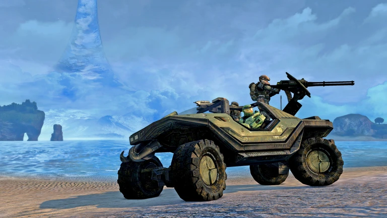 Ett Warthog-fordon med en soldat vid kulsprutan står på en strand i Halo: Combat Evolved, med hav och en blåskimrande ringvärldsstruktur i bakgrunden.