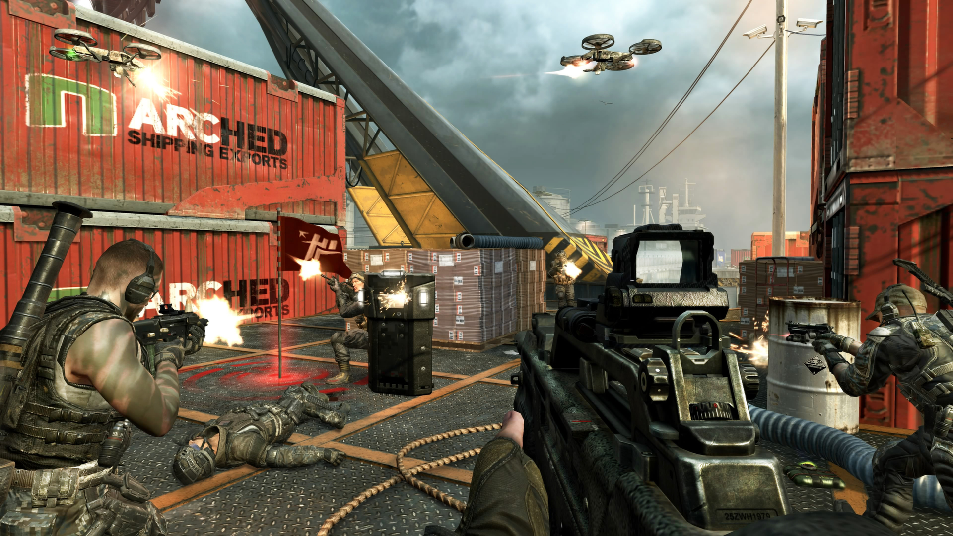 Förstapersonsvy från Call of Duty: Black Ops med ett automatgevär i förgrunden. Soldater skjuter mot varandra bland containrar på en hamnplats medan drönare flyger över.
