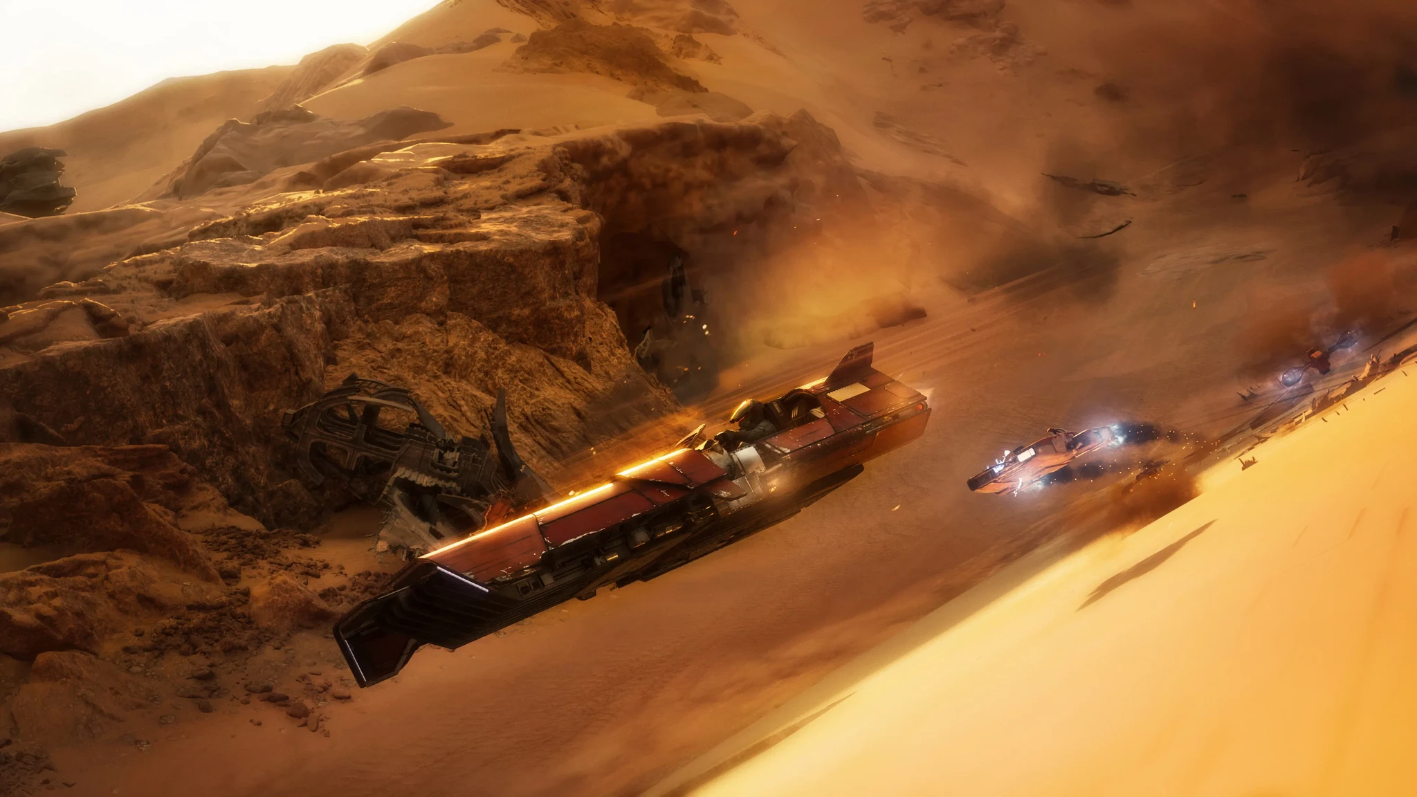 Två racerfarkoster rusar genom ett dammigt ökenlandskap med klippor och sanddyner i Star Wars: Galactic Racer, den större i förgrunden med glödande motorer.